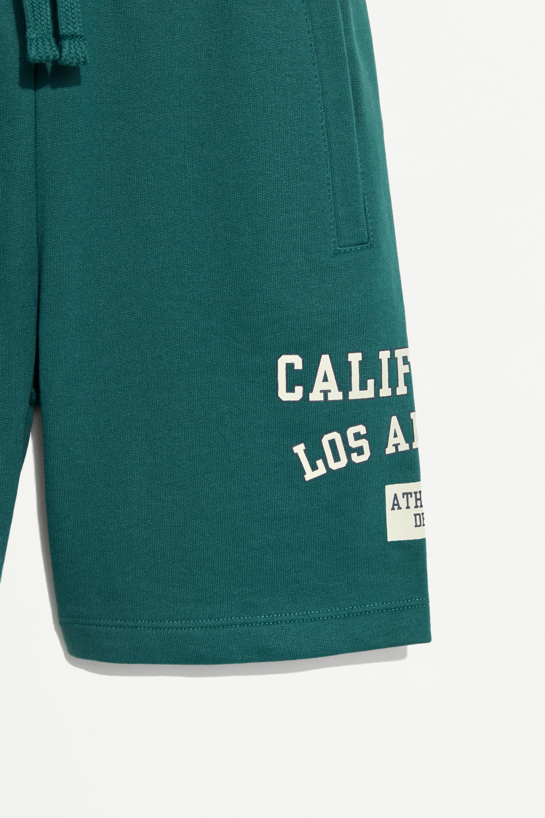 Plush Bermuda shorts with text